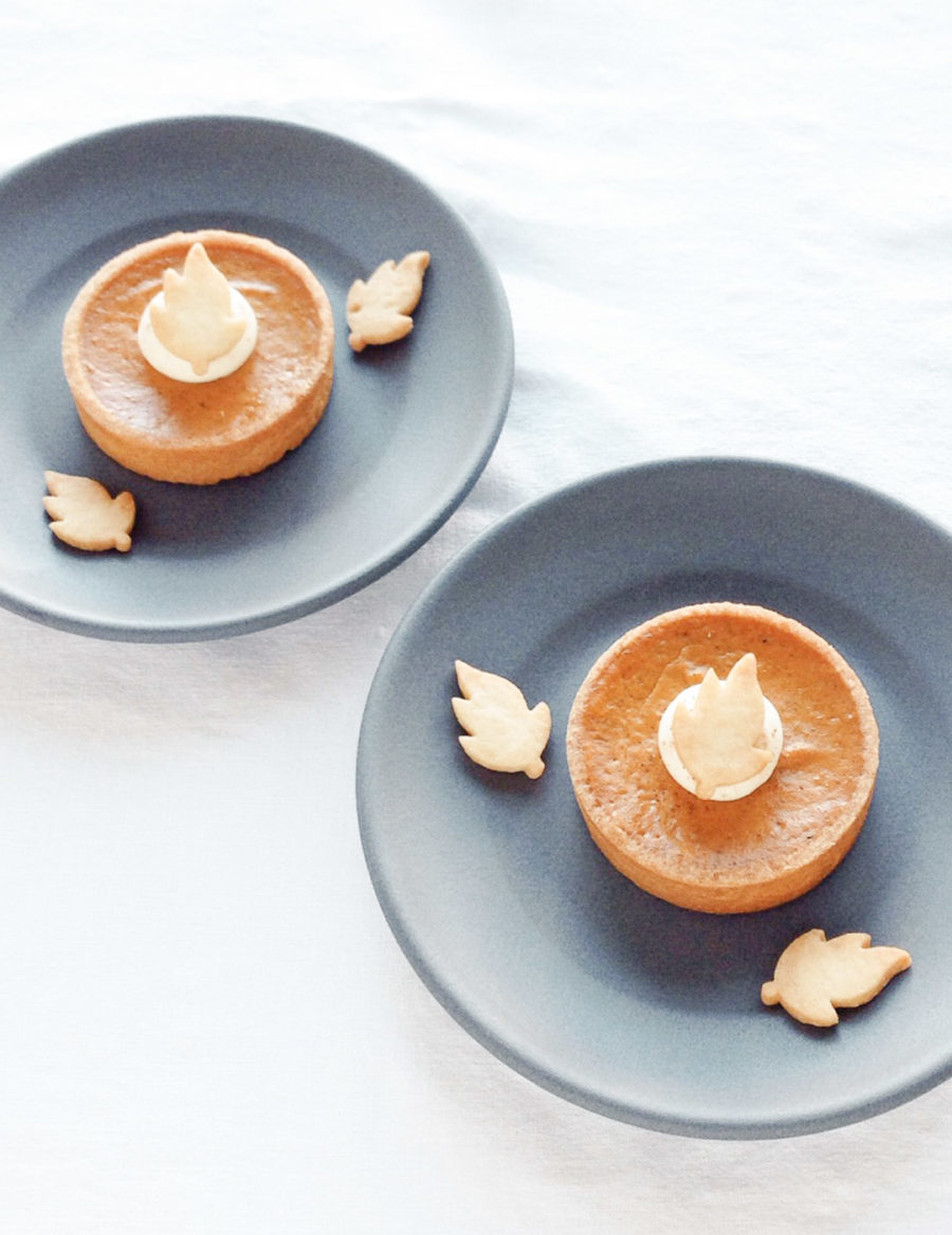 Pumpkin Tart Individual-sized pumpkin pie with buttery crust, spiced pumpkin filling, whipped cream, and a shortbread cookie leaf, perfect for Thanksgiving and fall treats